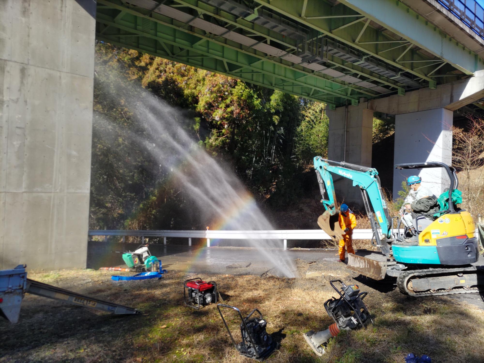 水道管が漏水し、道路から水が吹き出している画像