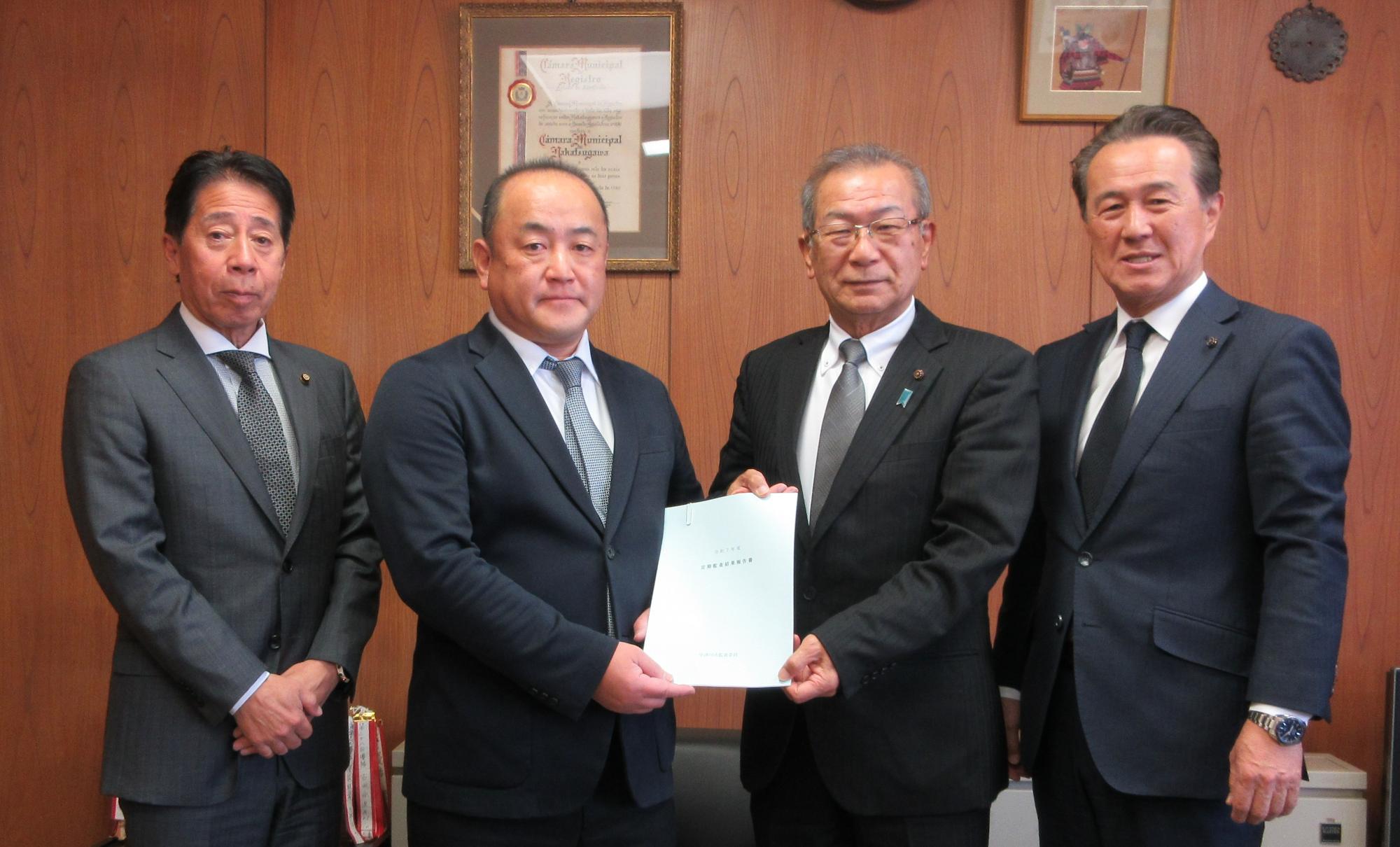 監査委員から市議会議長、副議長へ報告書が手渡される様子