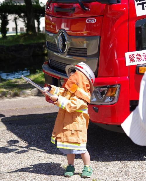 防火衣着装体験をする子供の様子