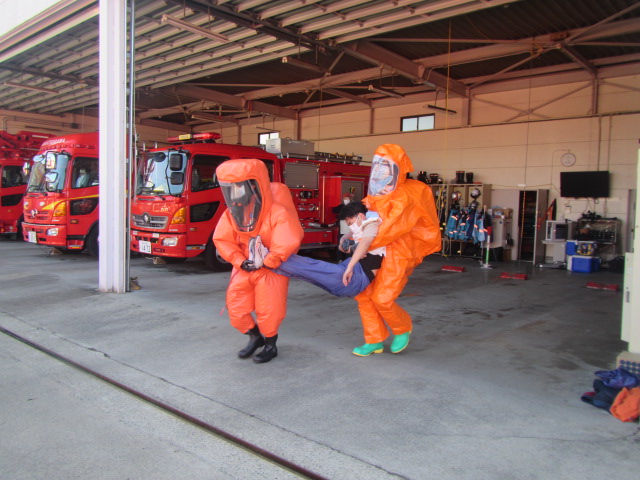 有毒物質から身体を守るための防護服を着装しての救出作業