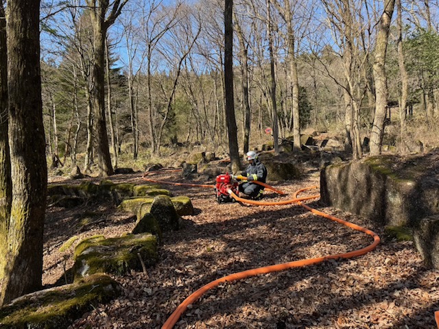 山林内で河畔ポンプを使用し、長距離中継送水を行っている様子。