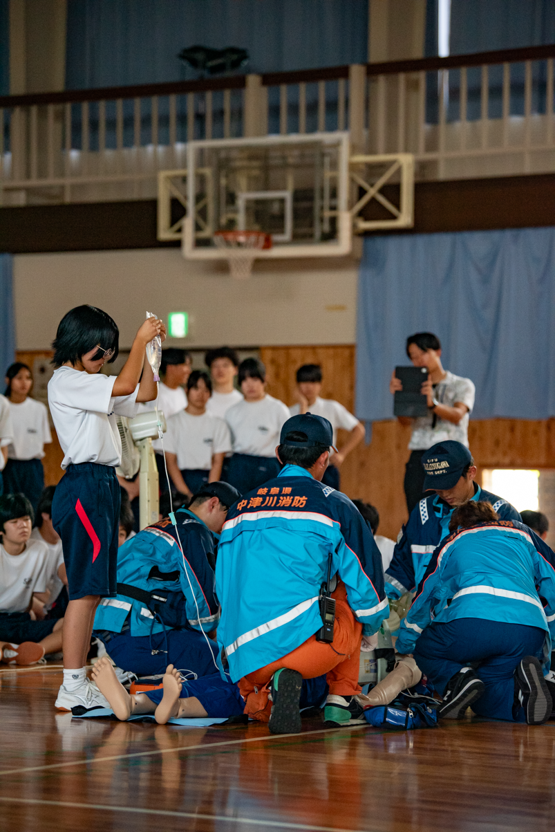 救急隊員が作業しているところで生徒さんがサポートしている様子